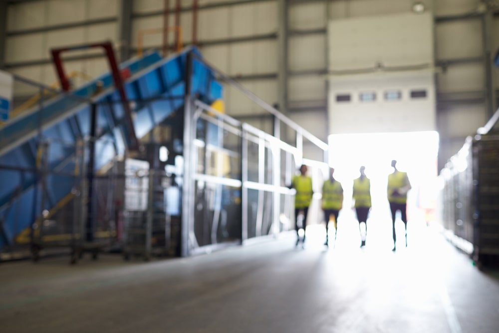 Sécurité et propreté industrielle représenté par une image de 4 caristes marchant en sécurité au sein d'une usine