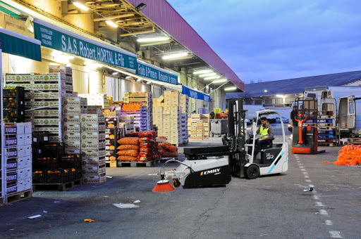 Balayeuse sur chariot en action de nettoyage dans les allés du marché international MERCADI